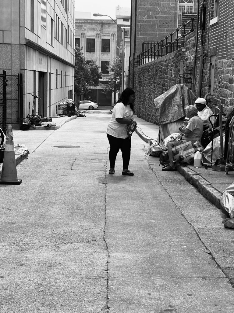black and white picture of woman helping homeless person